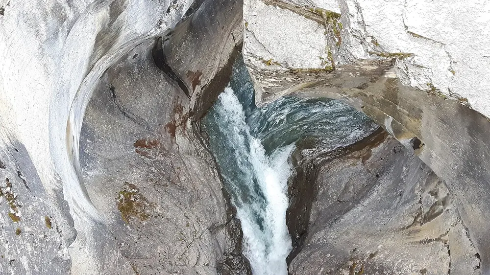 Mistaya Canyon: Wasser stürzt durch eine tief ausgewaschene, glatt geschliffene Kalksteinschlucht