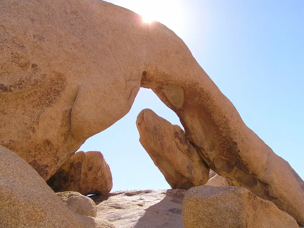 Arch Rock: natürlicher Felsbogen aus rundlich verwittertem Granit, unter dem der blaue Himmel hindurchscheint