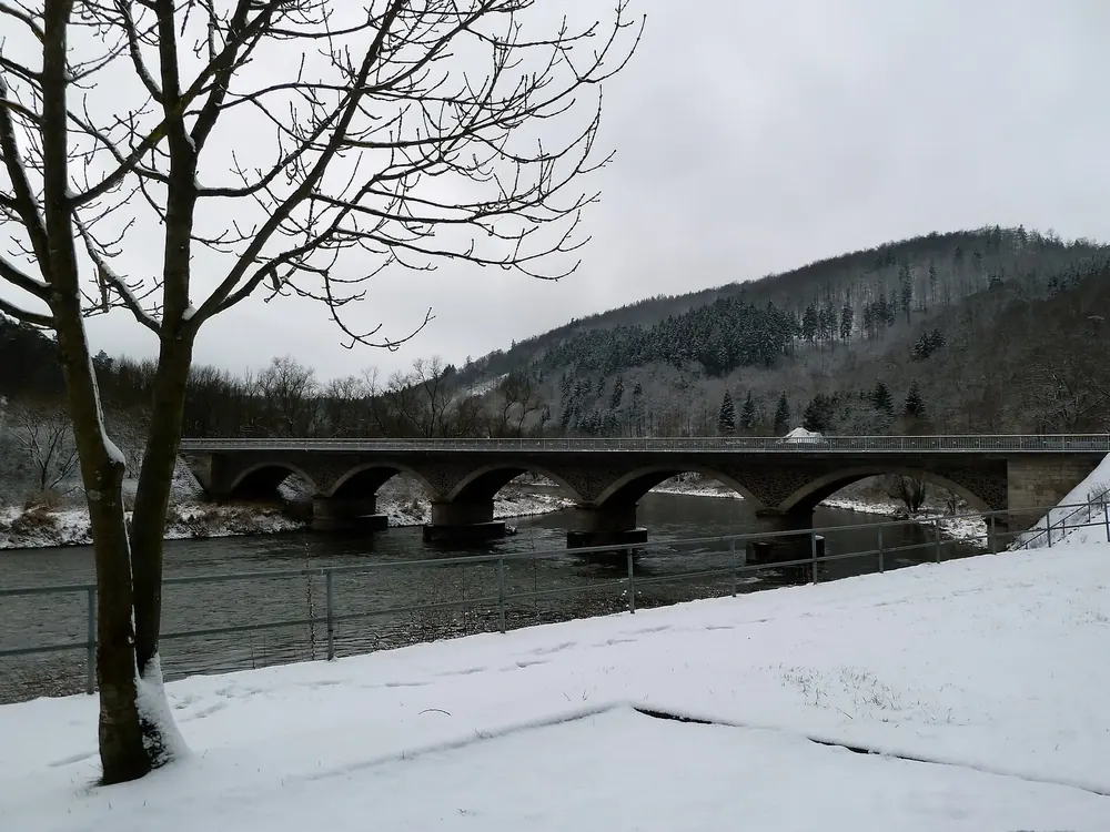 Bogenbrücke der L3084 über die Edersee-Talsperre bei Herzhausen im Winter, dahinter bewaldete Hänge