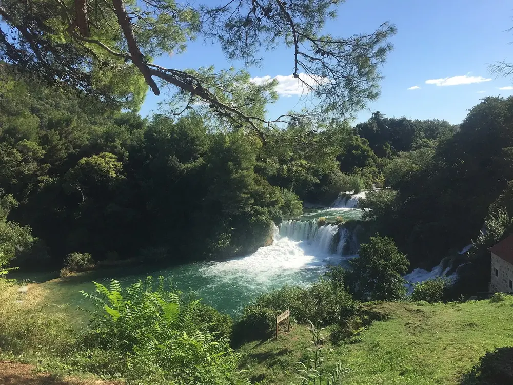 Kaskaden der Krka unterhalb von Lozovac: weiß schäumende Wasserfälle zwischen üppigem Grün und Kiefern