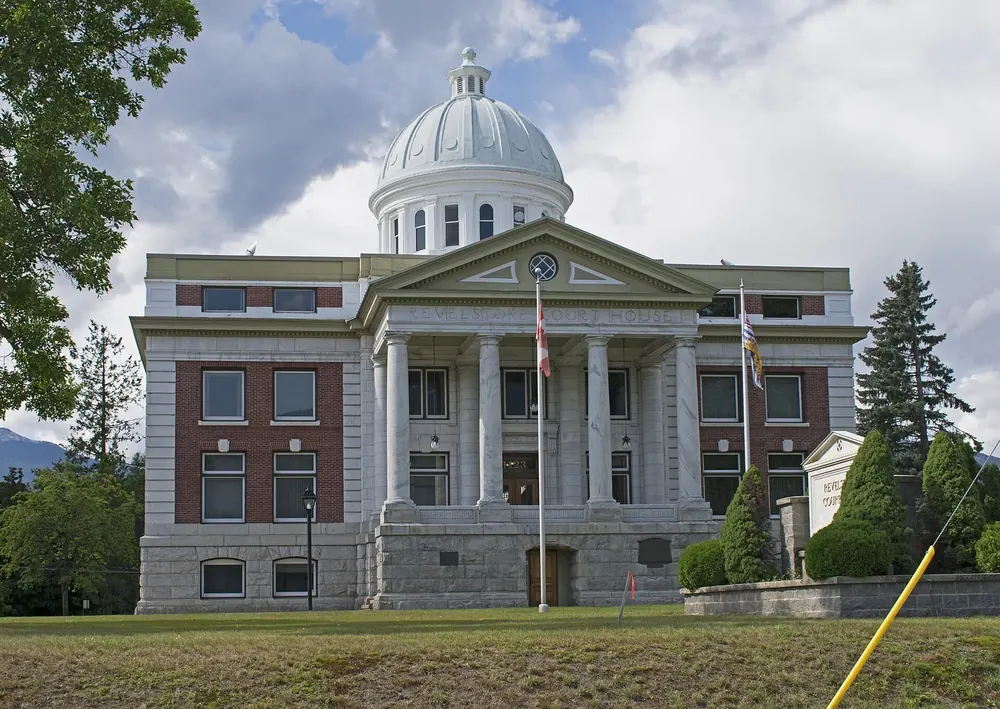 Revelstoke Courthouse: neoklassizistisches Gerichtsgebäude mit Säulenportal und Kuppel zwischen Bäumen