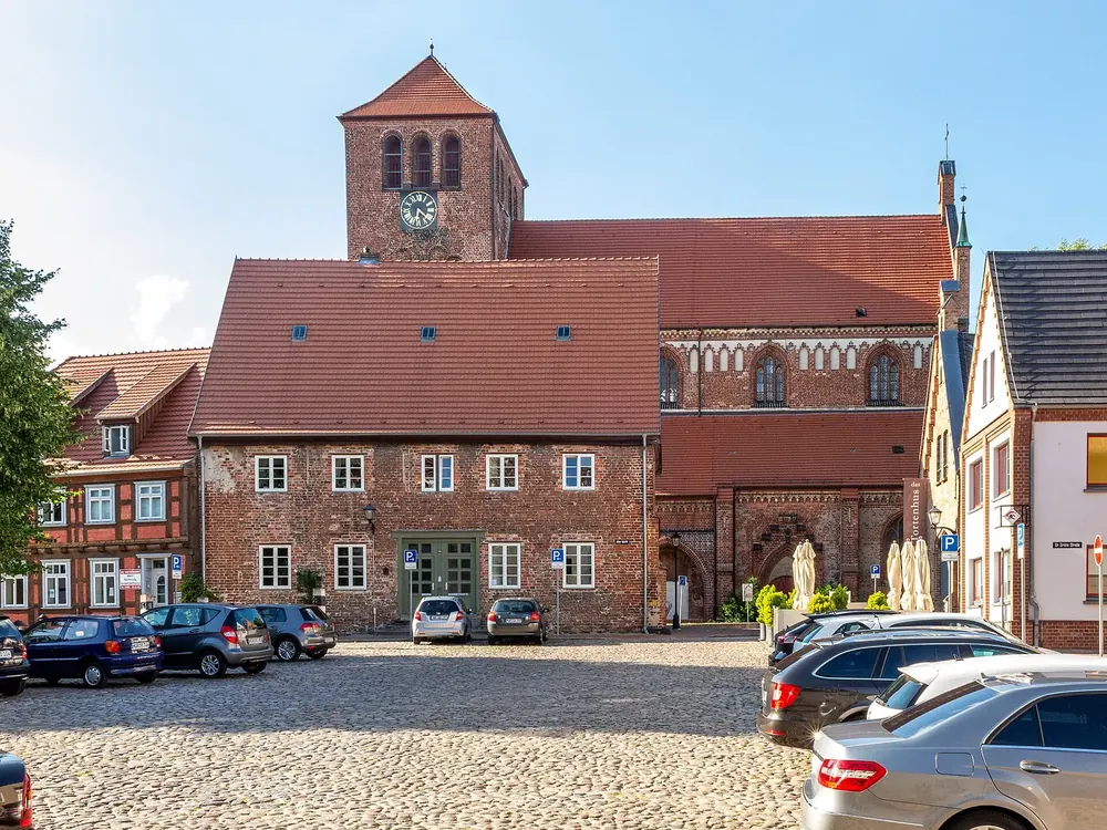 Alter Markt in Waren (Müritz) mit Backsteinbauten und dem Turm der Georgenkirche unter blauem Himmel