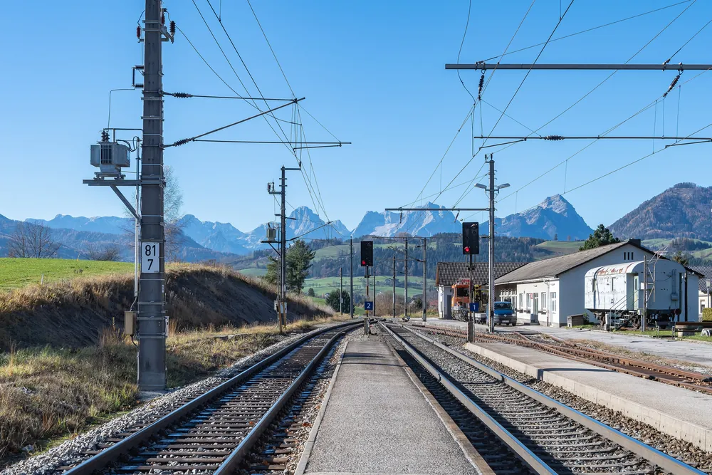 Gleise und Bahnsteig am Bahnhof Windischgarsten, dem Zielbahnhof für den Nationalpark Kalkalpen, mit Blick auf die Berge der Prielgruppe