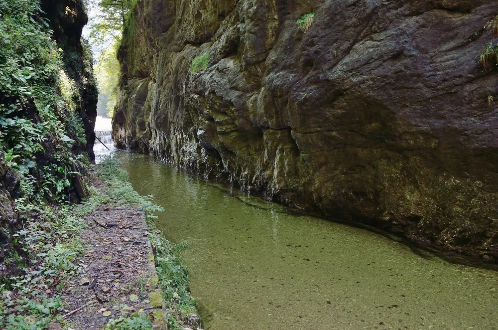 Die Große Klause am Großen Bach am Rand des Nationalpark Kalkalpen: ein Steig entlang einer Felswand über dem gestauten Bach