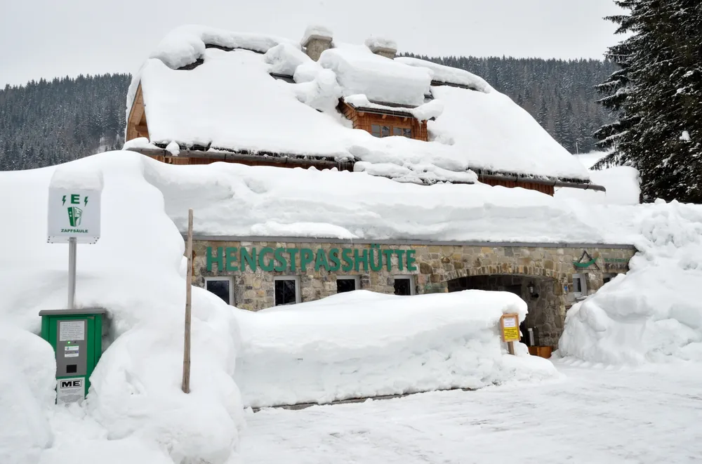 Die tief verschneite Nationalpark Hengstpasshütte an der Grenze des Nationalpark Kalkalpen mit Schild über dem Eingang