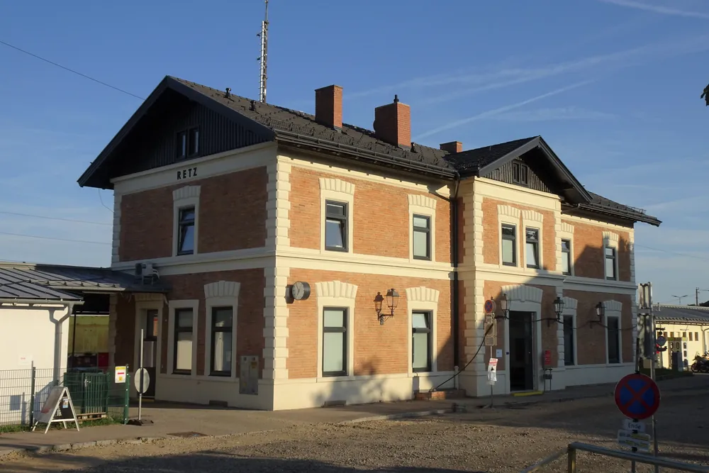 Das Bahnhofsgebäude von Retz aus Backstein und hellem Putz, nächster Bahnhof für die Anreise in den Nationalpark Thayatal