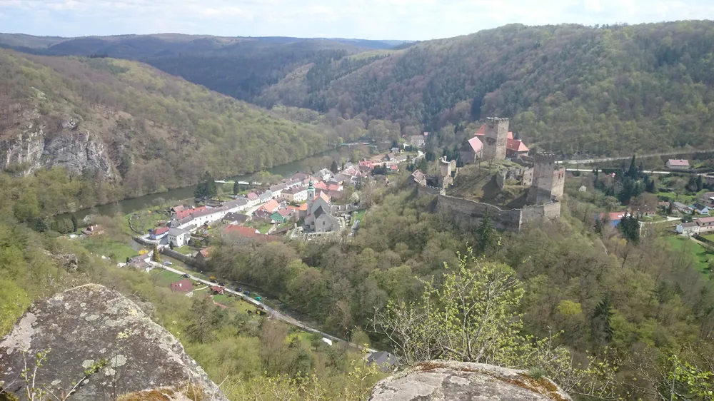 Blick vom Maxplateau im Nationalpark Thayatal über Felsblöcke hinab auf Hardegg mit Burg, Häusern und der Thaya im bewaldeten Tal