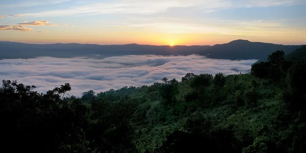 Blick von der Ngorongoro Serena Safari Lodge im Morgengrauen: Wolkenmeer im Krater unter dem Sonnenaufgang