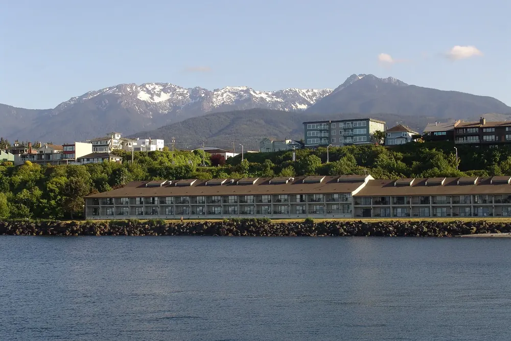 Port Angeles von der Hafenseite: Uferhotel und Häuser am Hang vor den schneebedeckten Olympic Mountains