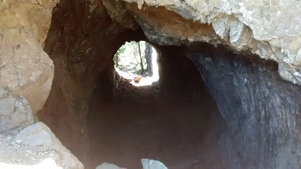 Blick durch den Daley-Rankin-Tunnel am Spruce Railroad Trail: kurzer Felstunnel mit hellem Ausgang