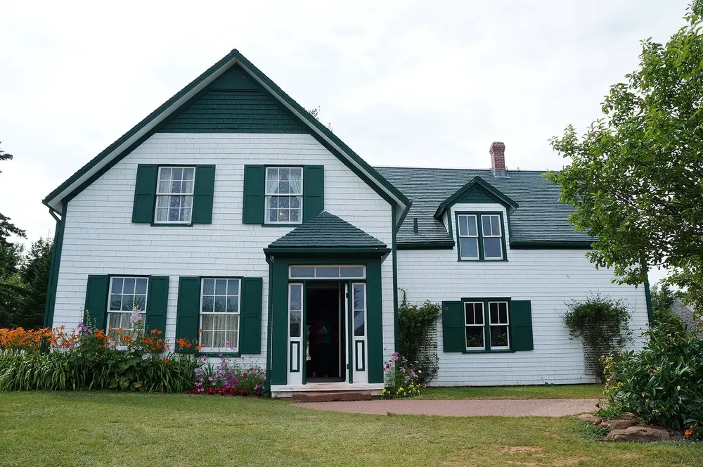 Green Gables House in Cavendish: weißes Holzhaus mit grünen Fensterläden und Giebeln, davor Blumenbeete und Rasen