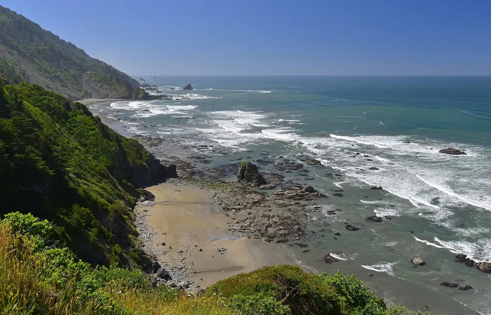 Blick vom Crescent Beach Overlook hinab auf Enderts Beach, felsige Brandungsküste und grüne Steilhänge