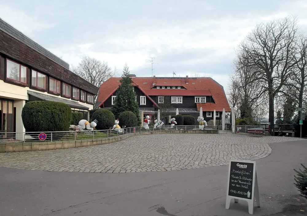 Berghotel auf der Bastei neben dem alten Schweizerhaus mit rotem Dach, davor ein gepflasterter Platz