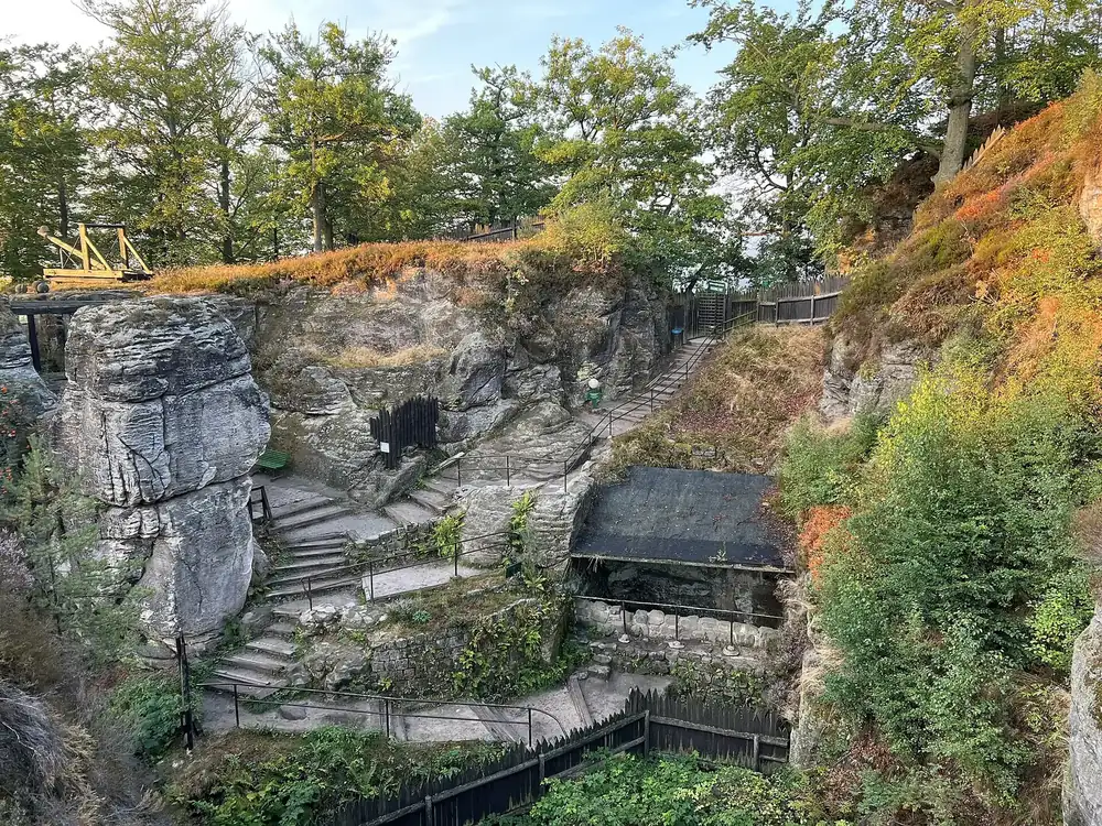 Burghof der Felsenburg Neurathen: Treppen und Stege zwischen Sandsteinfelsen, dazwischen Herbstlaub und Kiefern
