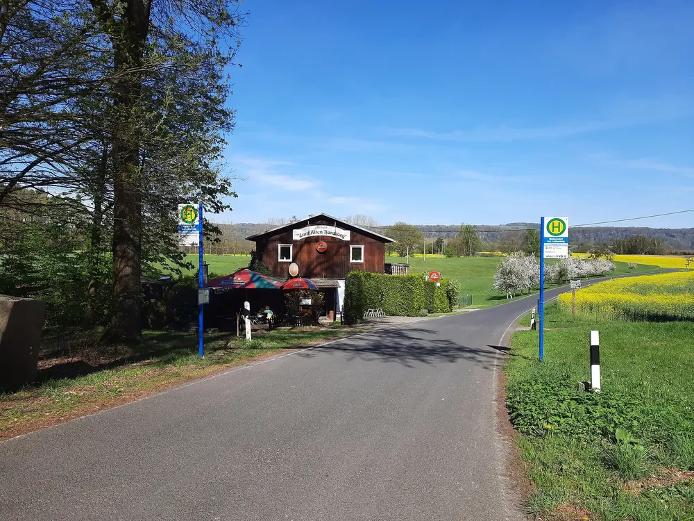 Wandergaststätte Zum Alten Hansjörg in Waltersdorf an der Liliensteinstraße, davor Bushaltestelle und blühende Rapsfelder