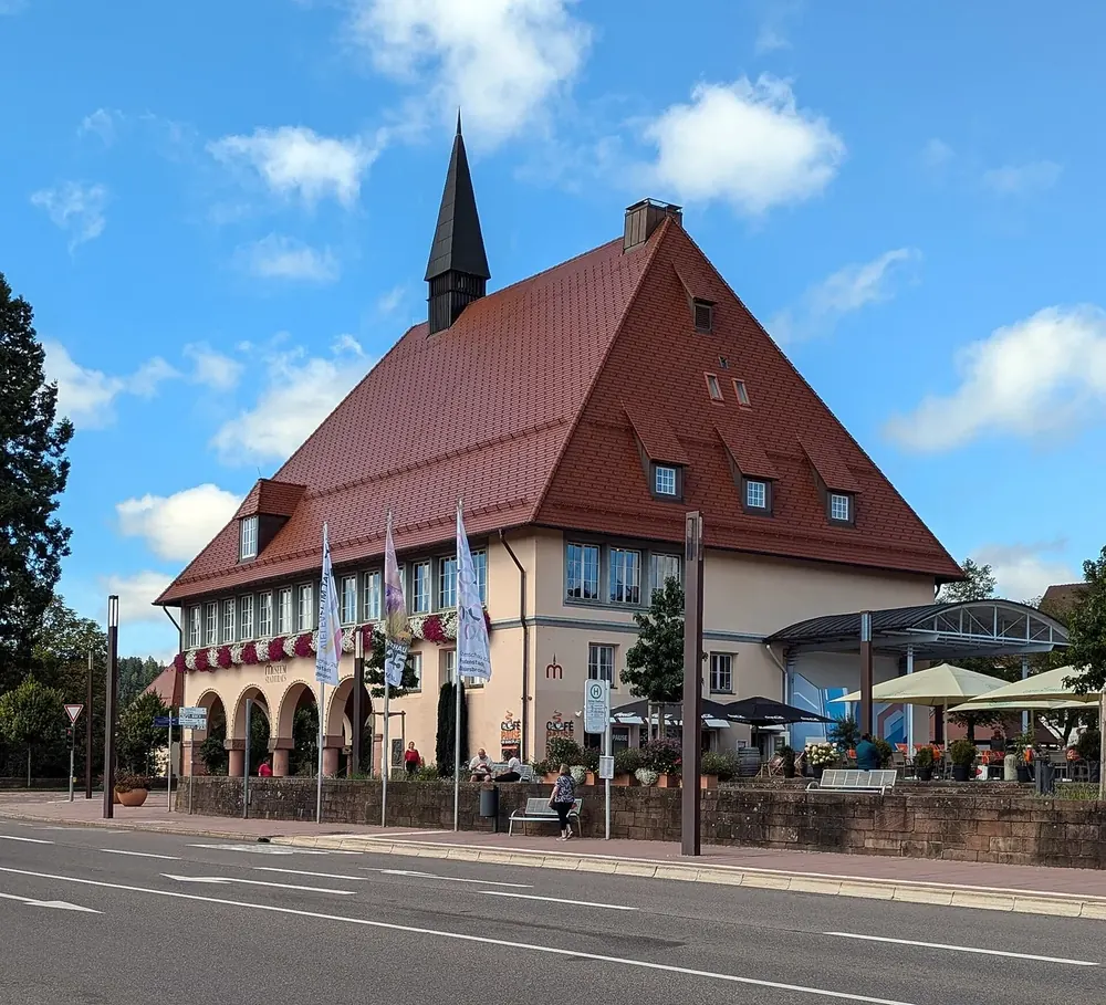 Stadthaus am Marktplatz von Freudenstadt: Bau mit Arkaden und steilem roten Dach mit Dachreiter unter blauem Himmel