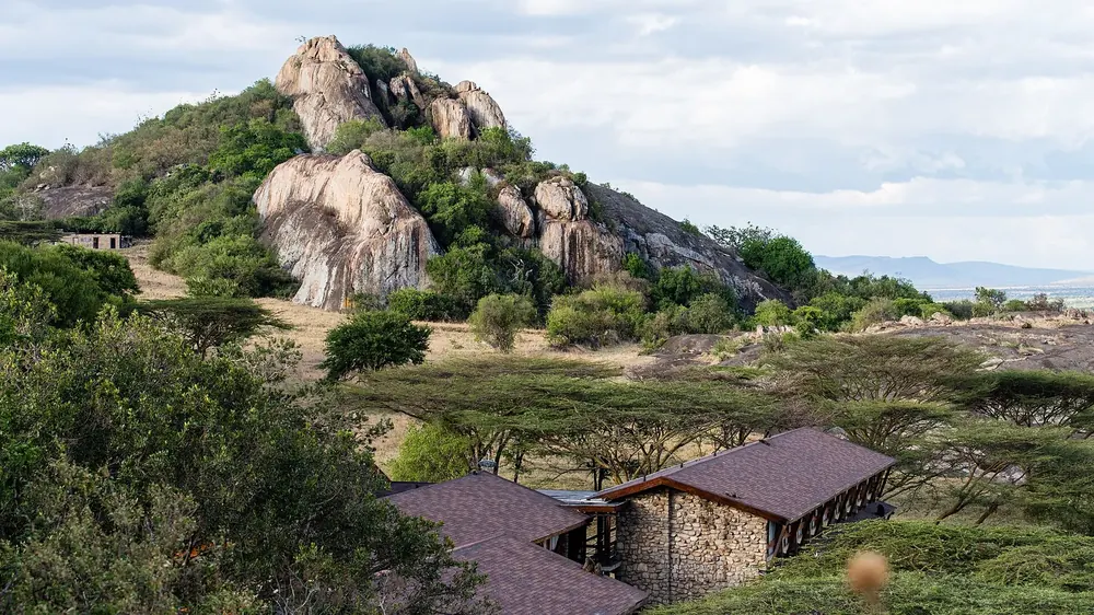 Lobo Wildlife Lodge: flache Steinbauten zwischen Akazien am Fuß großer, runder Granitkopjes