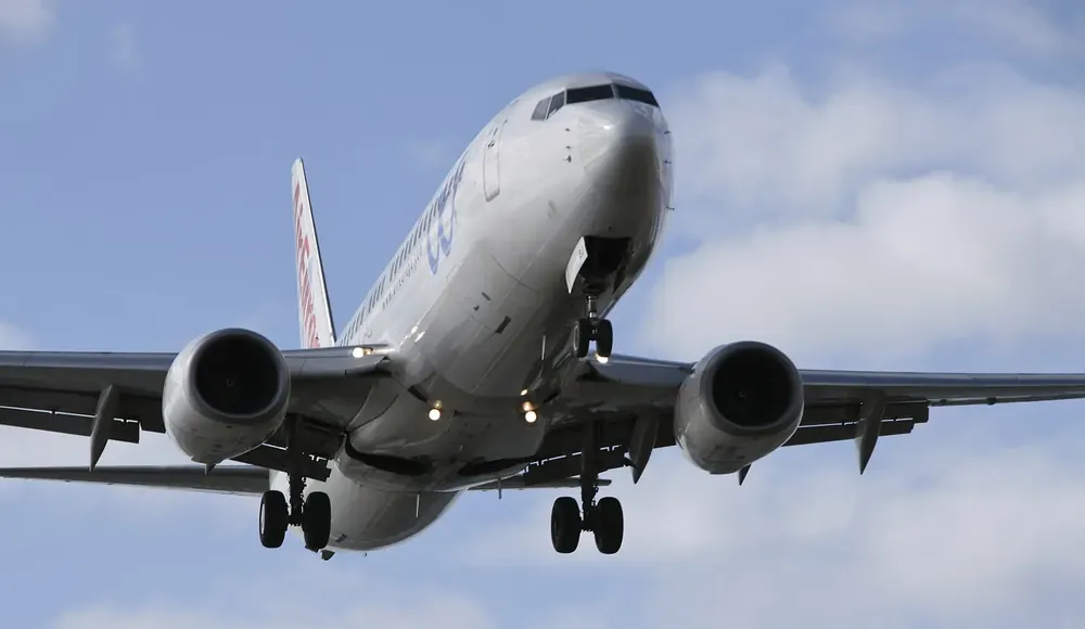 Verkehrsflugzeug im Landeanflug auf den Flughafen César Manrique bei Arrecife vor Wolkenhimmel