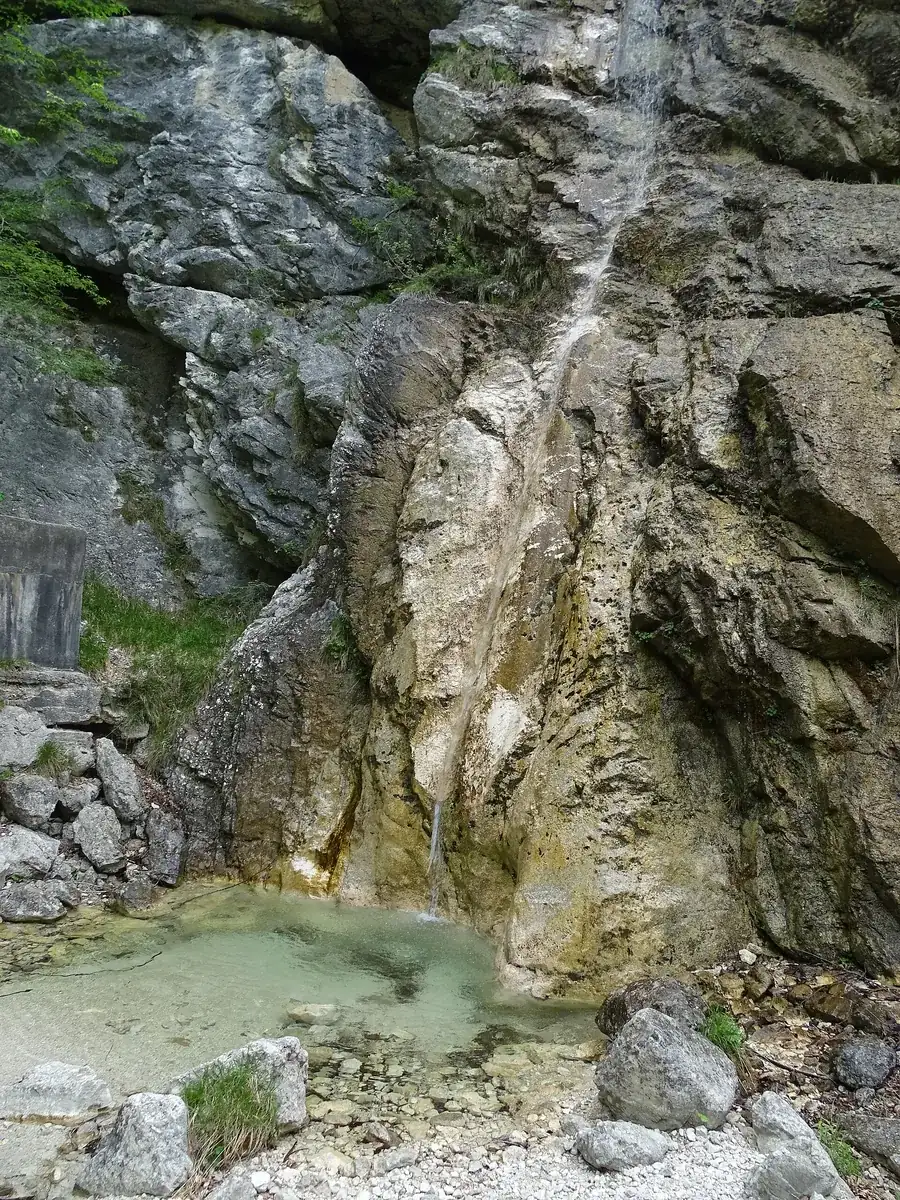 Wasserfall Slap pod Kukljo im Alpengarten Juliana: schmales Rinnsal über graue Felswand in ein kleines Becken