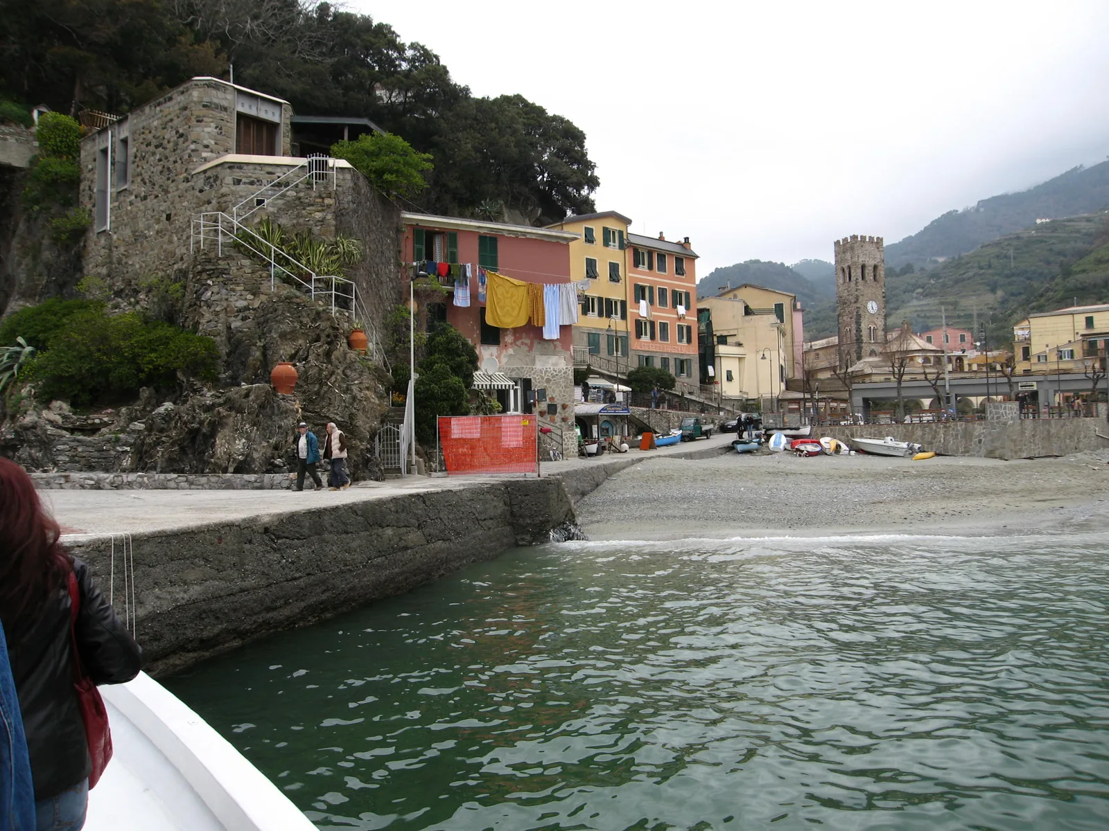 Am Strand der Altstadt von Monterosso al Mare: bunte Häuser, ein Turm und Boote auf dem Kies