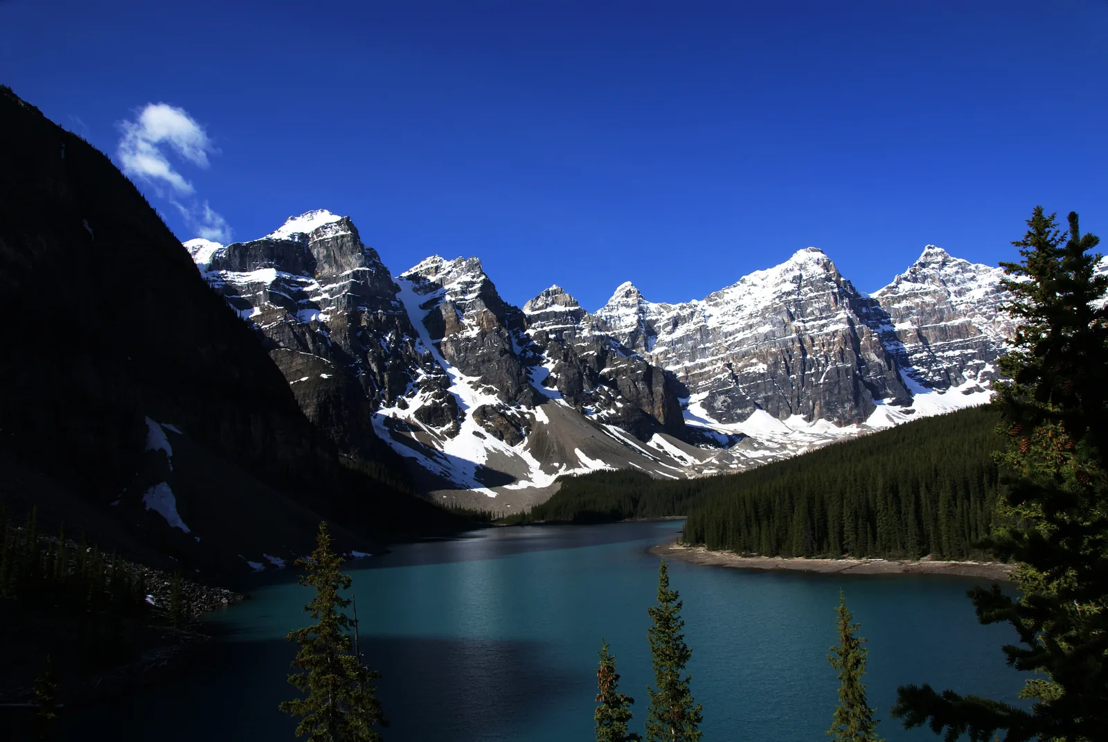 Blick vom Rockpile über den dunkelblauen Moraine Lake auf verschneite Gipfel