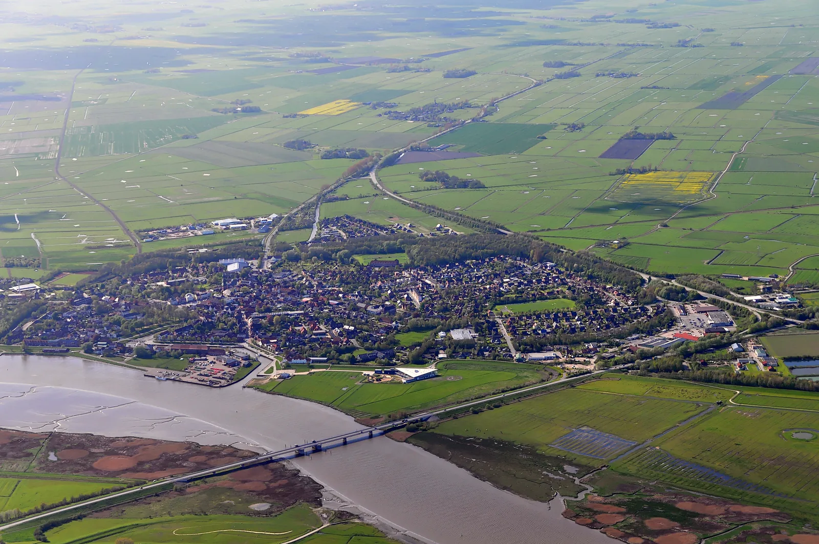 Luftbild von Tönning an der Eider mit Brücke, Hafen und dem hellen Bau des Multimar Wattforums am Deich