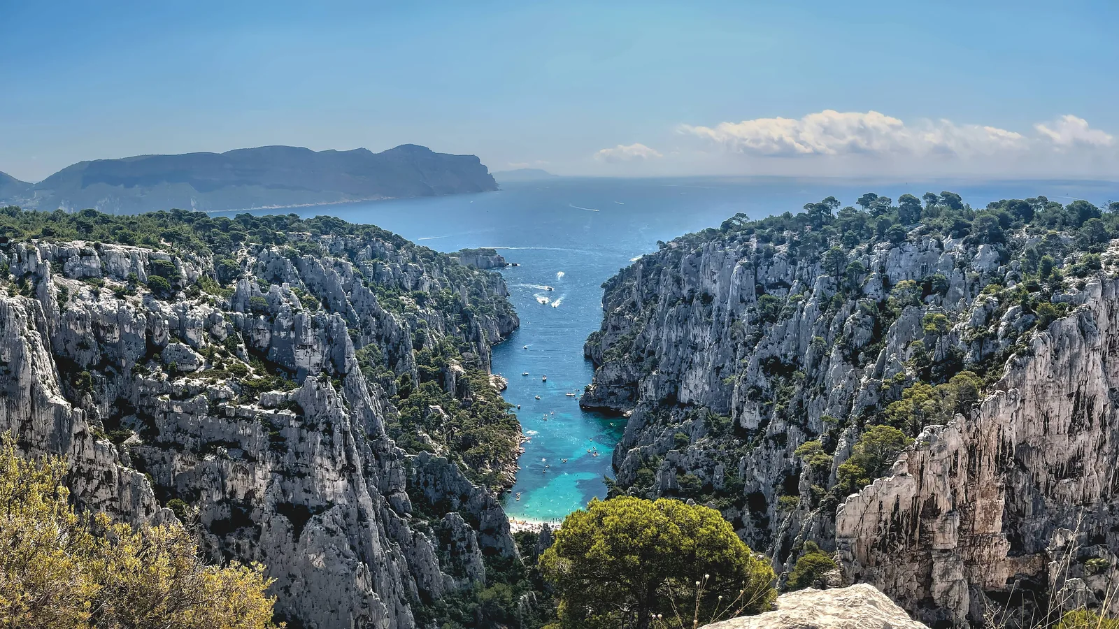 Blick vom Belvédère d’En-Vau im Nationalpark Calanques: steile Kalkwände, dazwischen die türkise Bucht von En-Vau, dahinter das Meer und das Cap Canaille