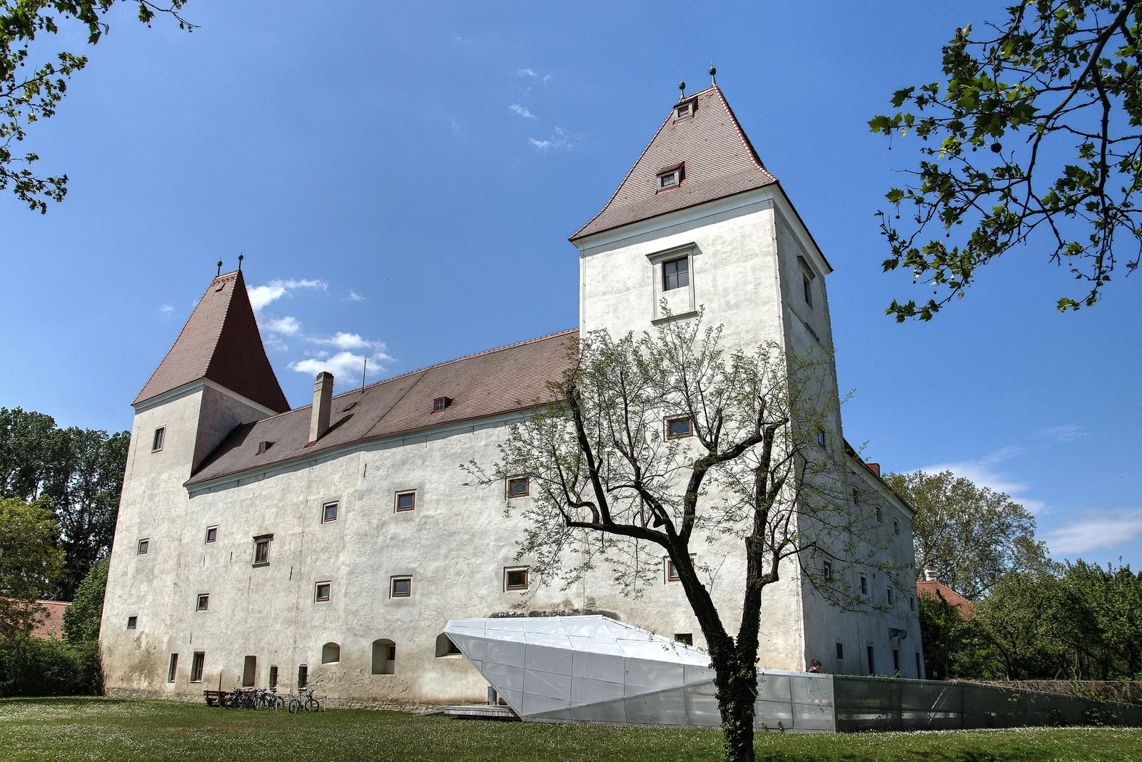 Das weiße Schloss Orth mit spitzen roten Turmdächern, Nationalparkzentrum am Rand des Nationalparks Donau-Auen