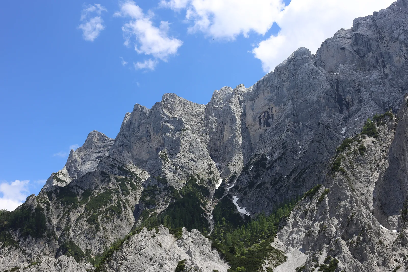 Die steilen Kalknordwände von Rosskuppe und Hochtor im Nationalpark Gesäuse unter blauem Himmel