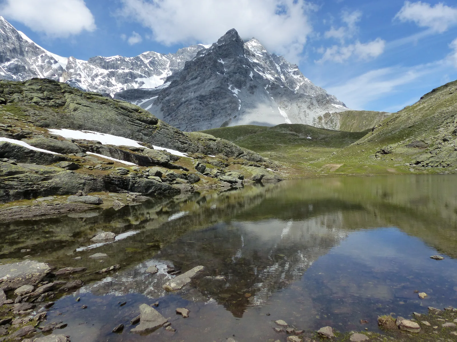 Der Hintergratsee unter dem Hintergrat des Ortlers im Nationalpark Stilfserjoch, im Wasser spiegeln sich die Felsen