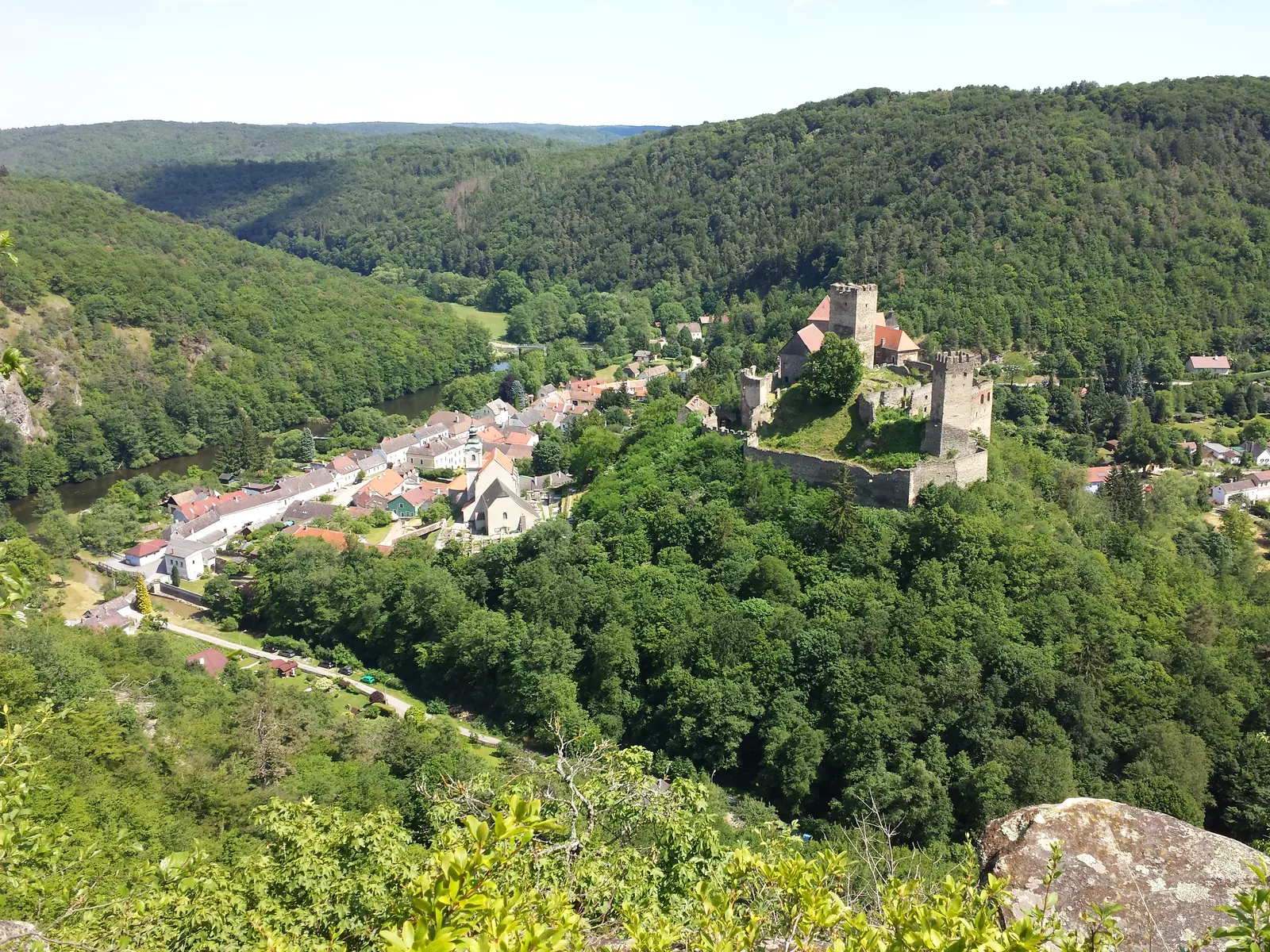 Blick vom Maxplateau auf die Burg Hardegg und die Häuser der Stadt im Nationalpark Thayatal, ringsum bewaldete Hänge