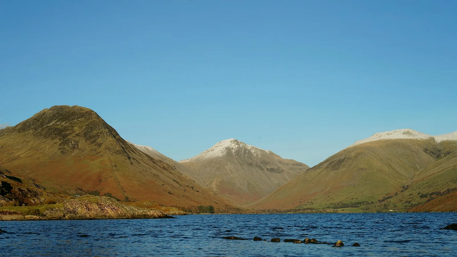 Der Berg Great Gable über dem See Wast Water im Lake-District-Nationalpark unter blauem Himmel