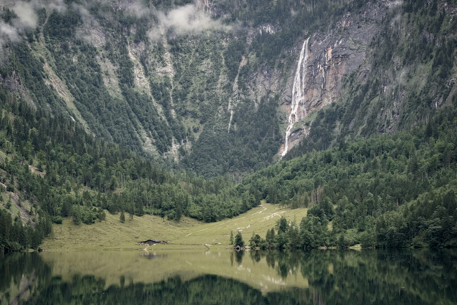 Der Obersee im Nationalpark Berchtesgaden mit Spiegelung, dahinter die Fischunkelalm und der Röthbachfall an der Röthwand
