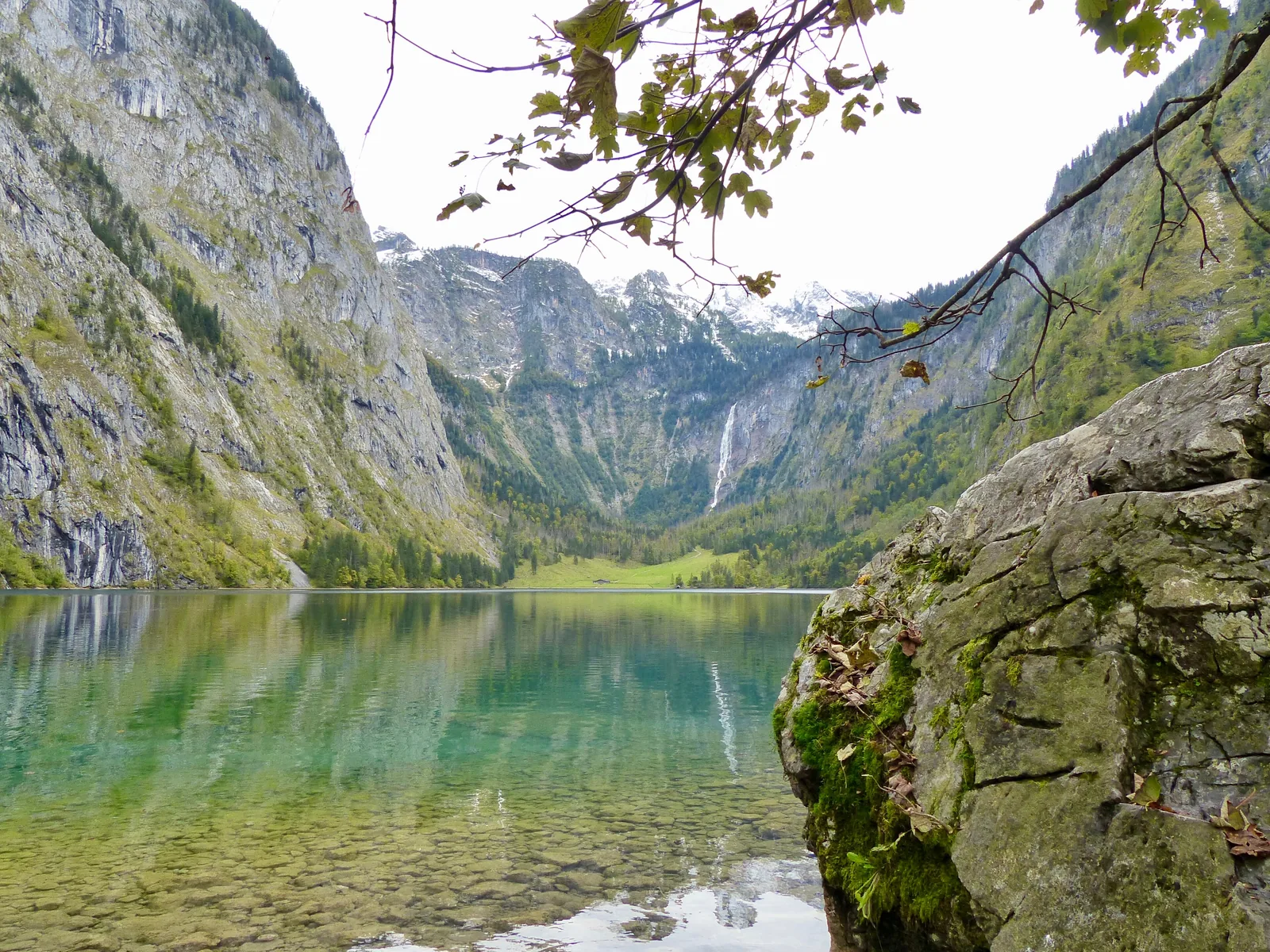 Klares Wasser und Felsblock am Ufer des Obersees, im Hintergrund der Röthbachfall im Talschluss