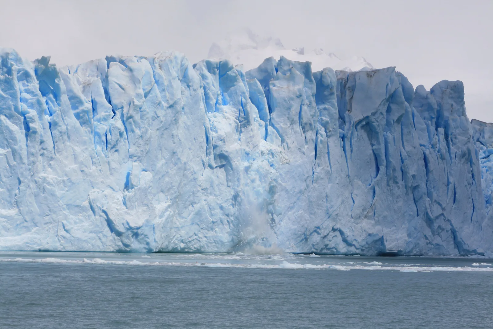 Die steile, zerklüftete Eisfront des Perito-Moreno-Gletschers im Nationalpark Los Glaciares, davor treibt Eis auf dem See