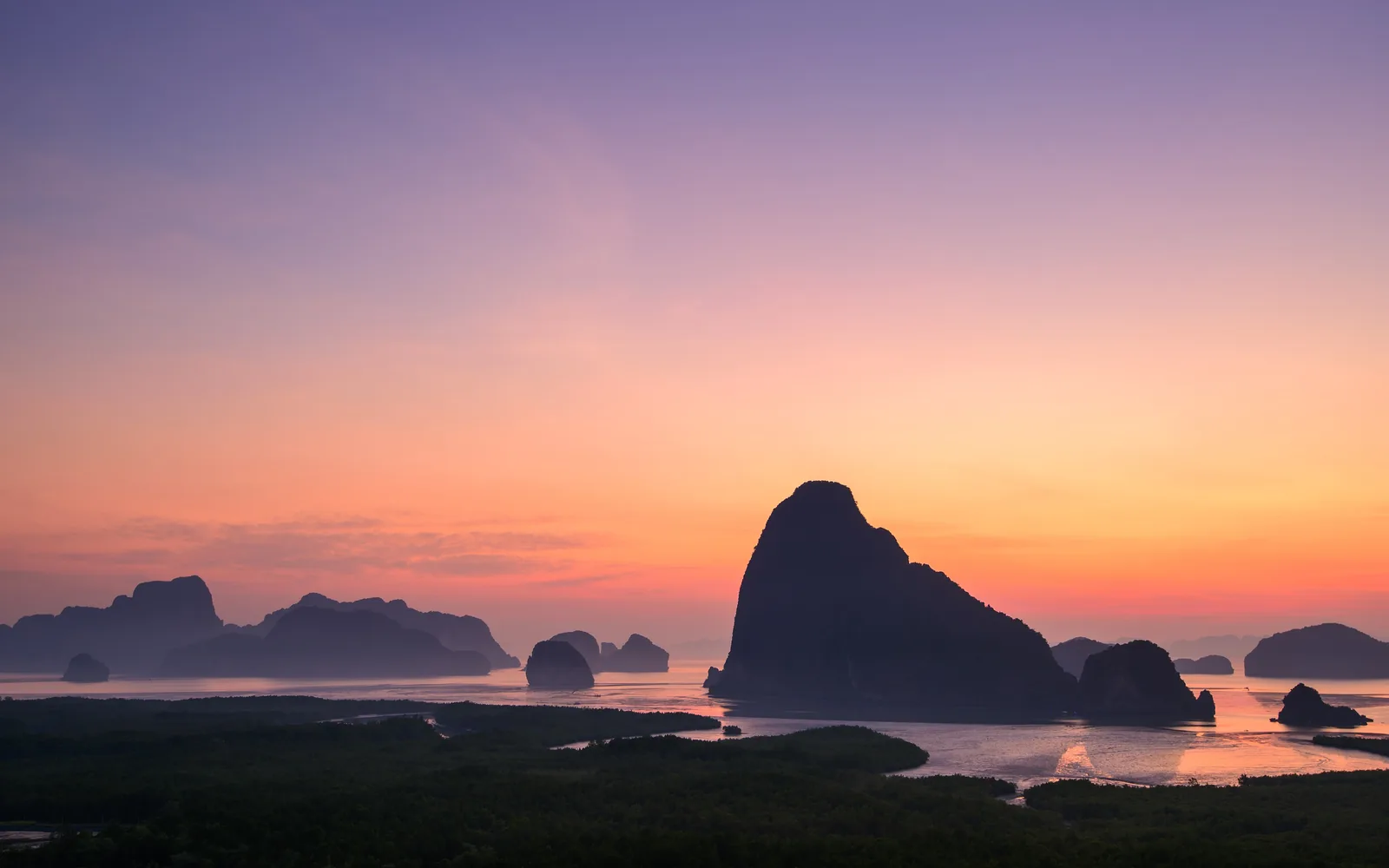 Morgenrot über der Phang-Nga-Bucht, davor die dunklen Umrisse der Kalkinseln und Mangroven