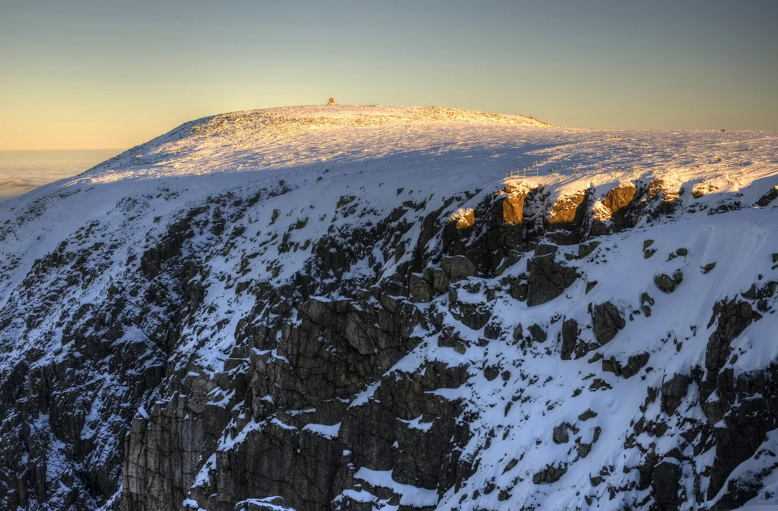 Das Hohe Rad im Riesengebirge im Abendlicht über verschneiten Felswänden, gesehen von den Schneegruben