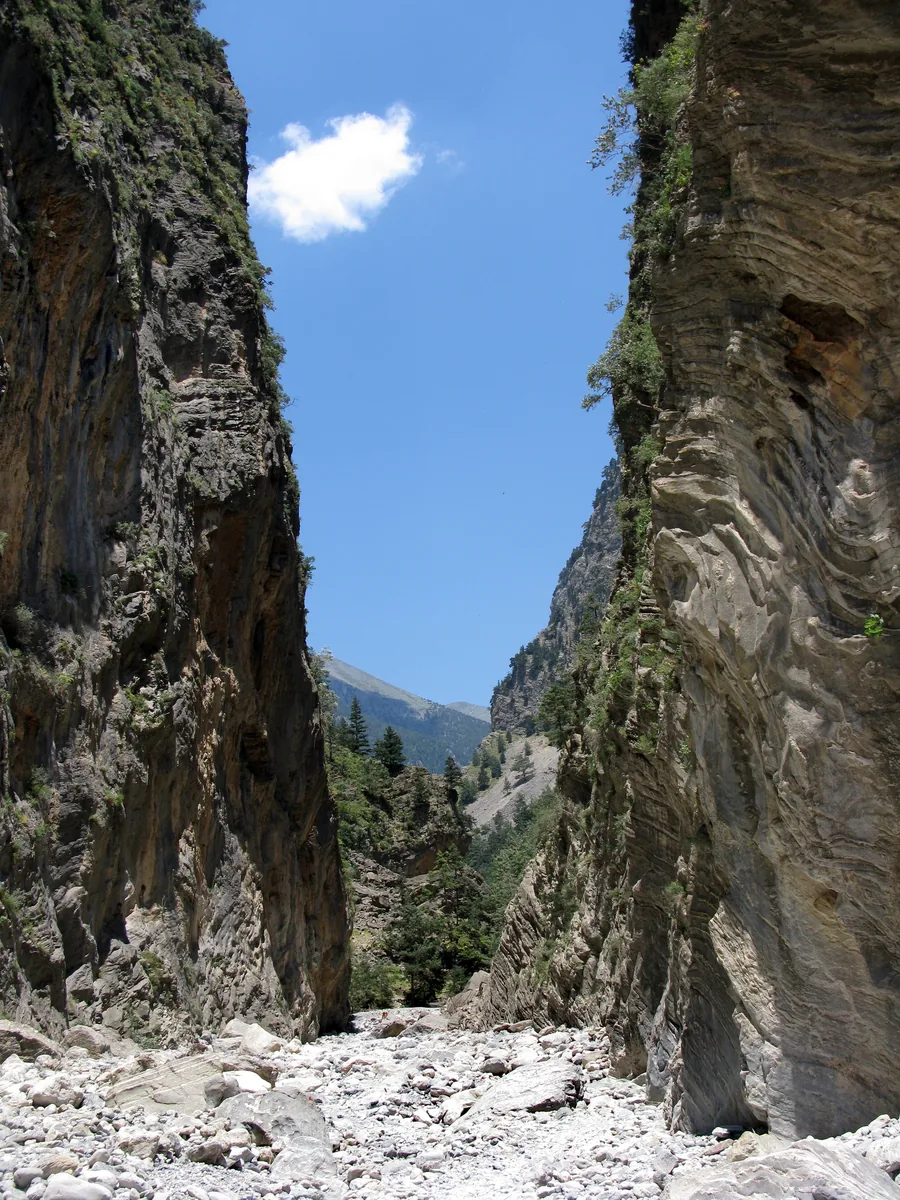 Die Portes in der Samaria-Schlucht: zwei senkrechte Felswände stehen eng beieinander, dazwischen ein Streifen Himmel und Geröll