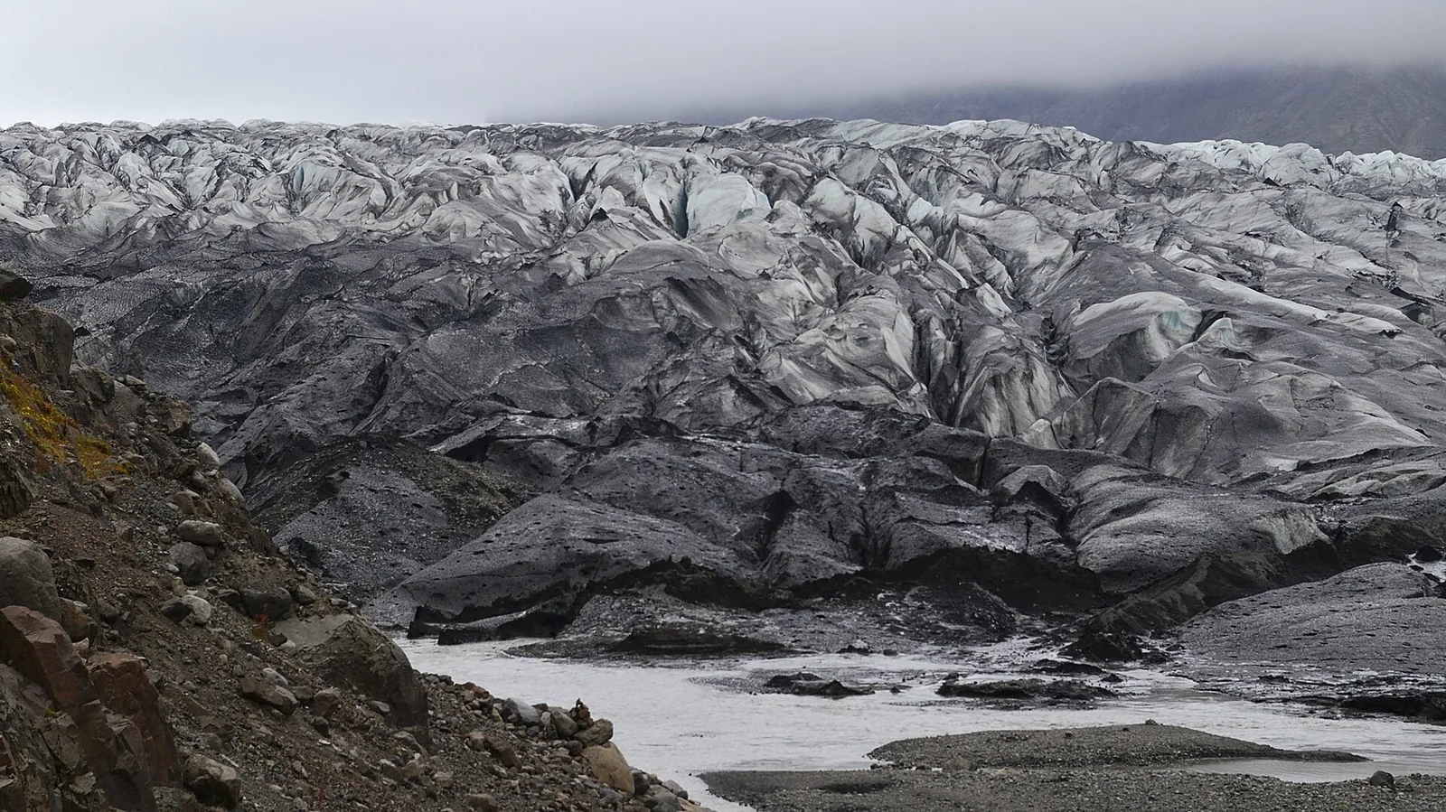 Die zerklüftete Zunge des Skaftafellsjökull in Skaftafell, davor Moränenschutt und Schmelzwasser