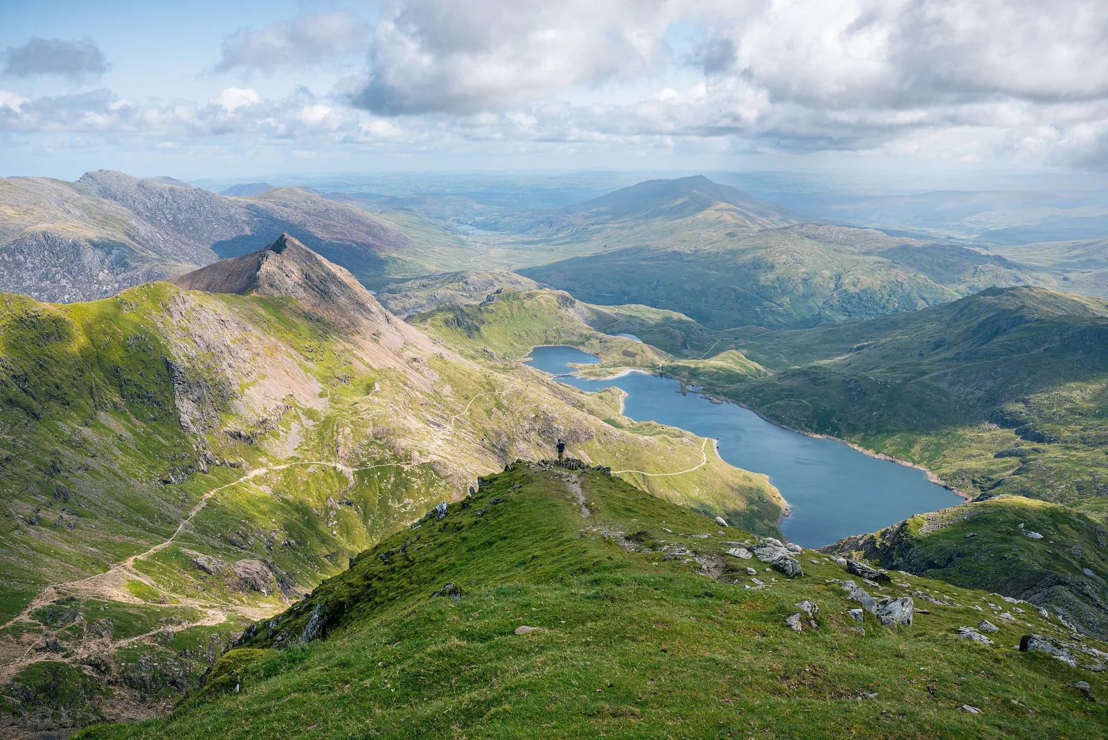 Blick vom Gipfelbereich des Snowdon (Yr Wyddfa) im Snowdonia-Nationalpark hinab auf den See Llyn Llydaw, links der Grat Crib Goch