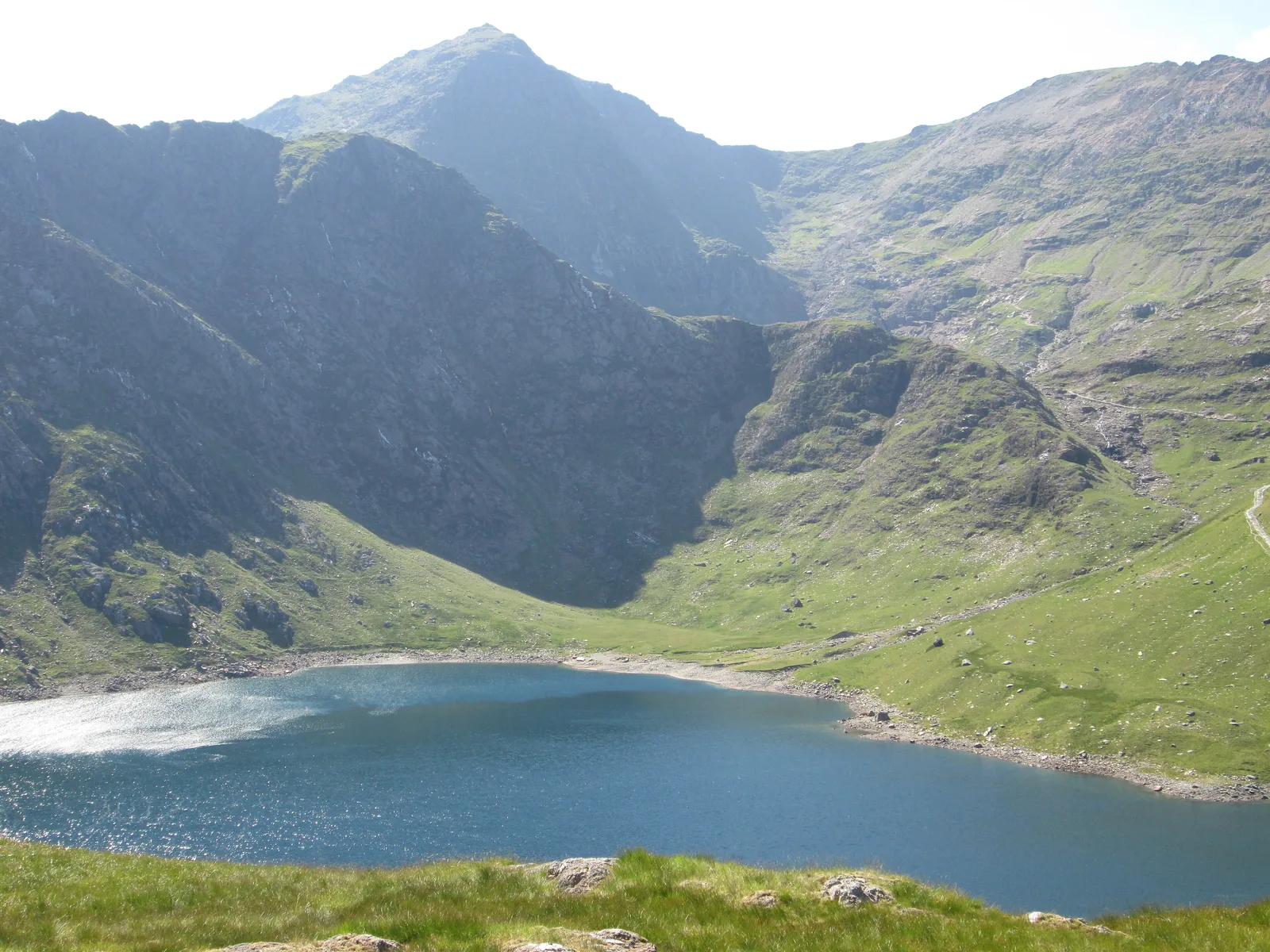 Der See Llyn Llydaw im Snowdonia-Nationalpark, darüber der spitze Gipfel des Snowdon (Yr Wyddfa)