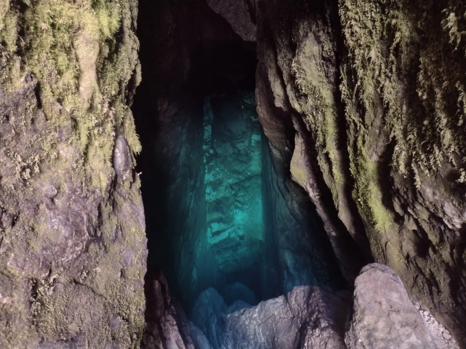 Blick in die Höhle der Soča-Quelle mit tiefem, grünblauem Wasser