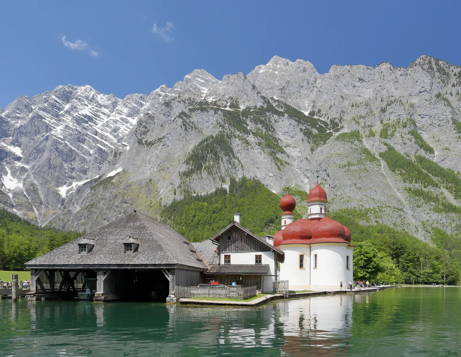 Die Wallfahrtskirche St. Bartholomä mit roten Zwiebeltürmen am Ufer des Königssees, dahinter die Watzmann-Ostwand