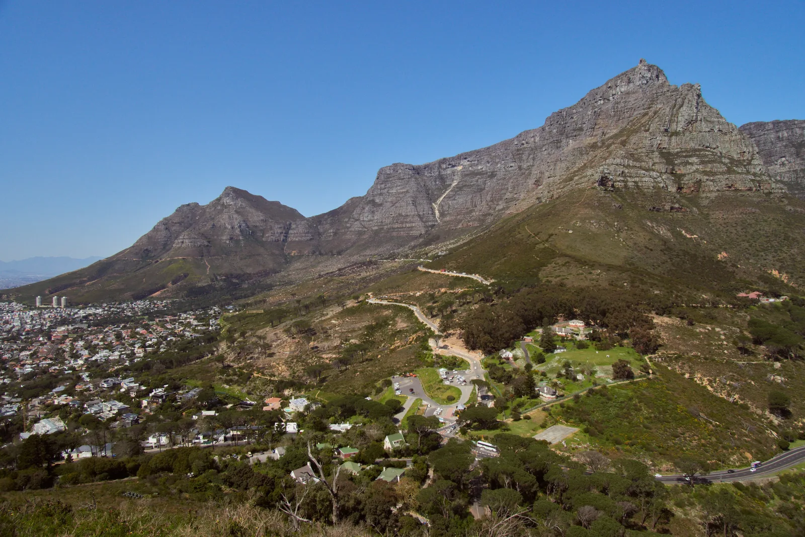 Blick vom Lion’s Head auf den Tafelberg und Devil’s Peak, darunter die Häuser von Kapstadt und die Straße zur Kloof Nek