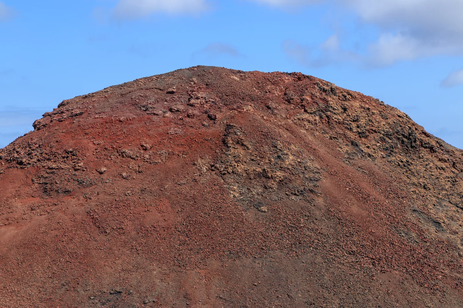Der rote Aschekegel der Montaña del Balcón im Timanfaya-Nationalpark unter blauem Himmel