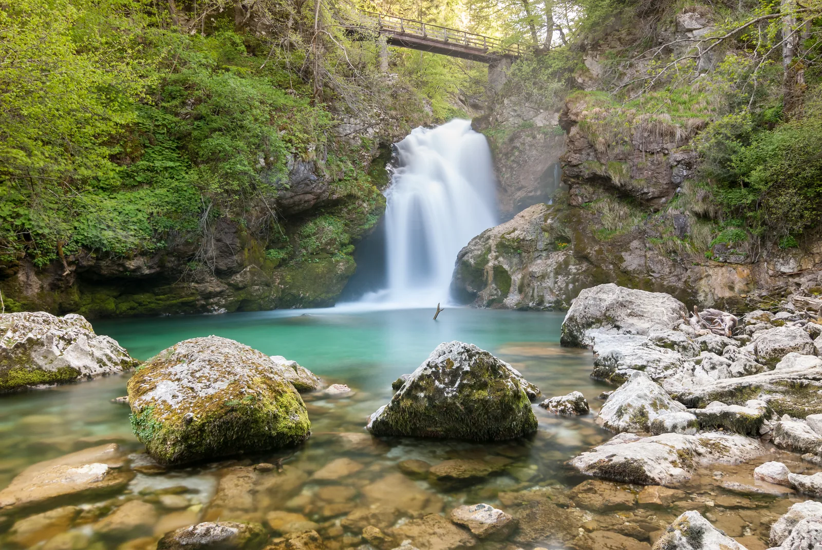 Der Wasserfall Šum am Ende der Vintgar-Klamm, davor ein klares, türkisfarbenes Becken
