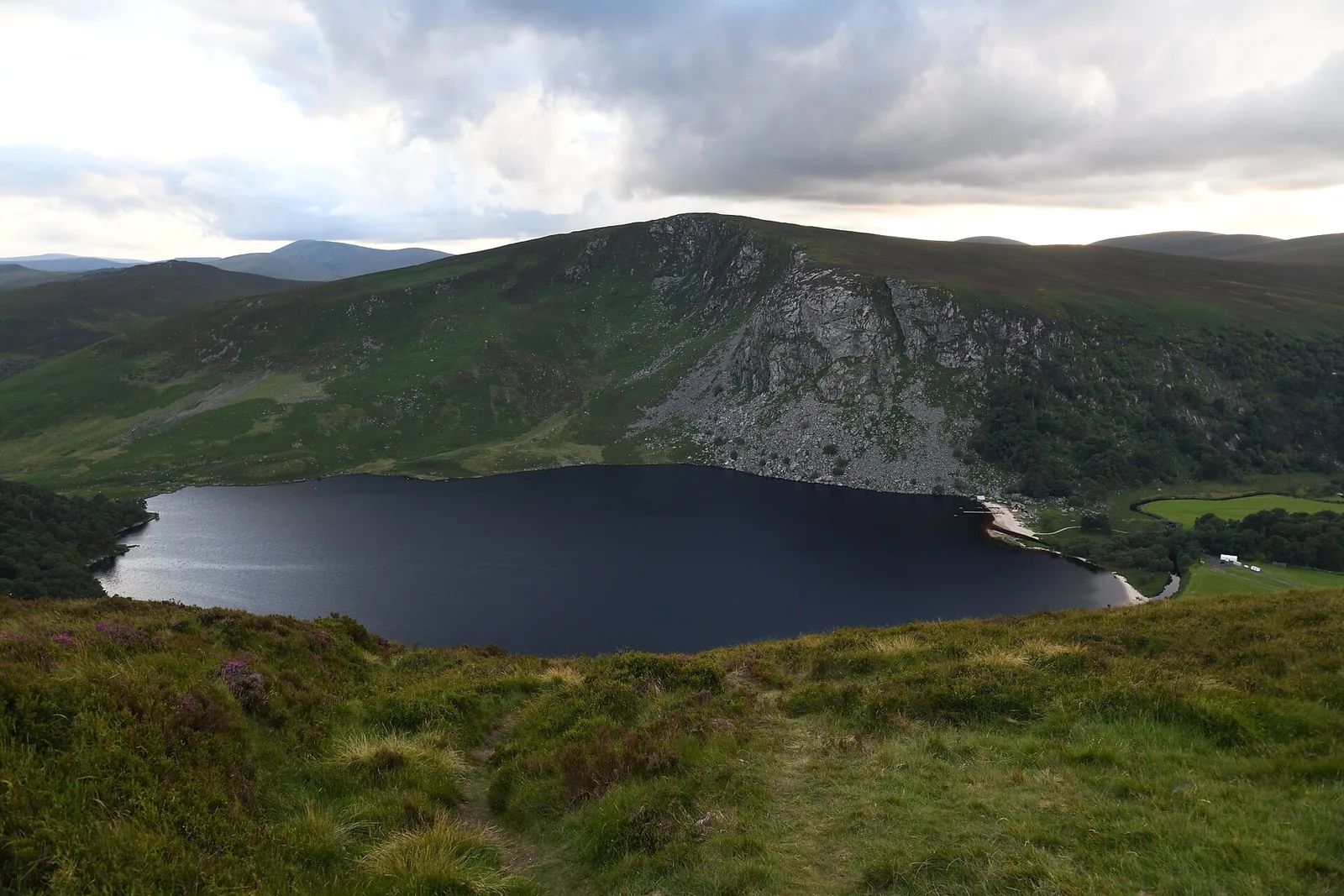 Lough Tay in den Wicklow Mountains, ein dunkler See unter steilen braunen Hängen