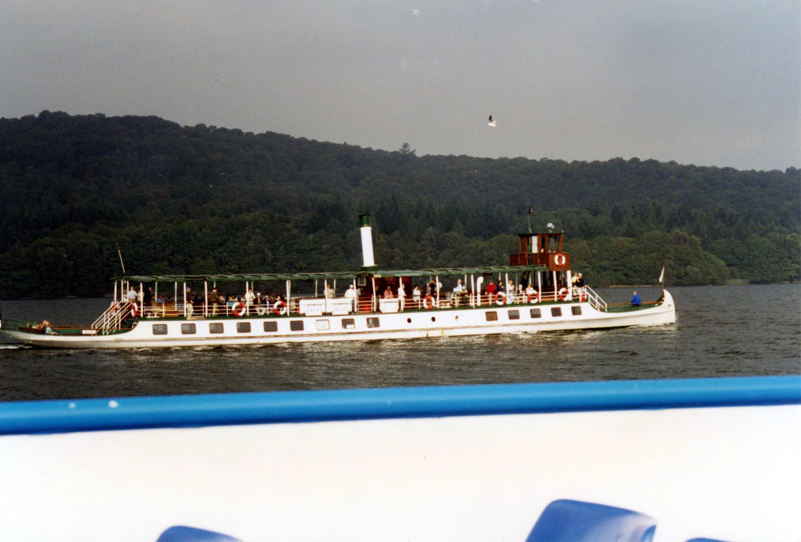 Das historische Motorschiff Tern von Windermere Lake Cruises auf dem Windermere vor einem bewaldeten Ufer