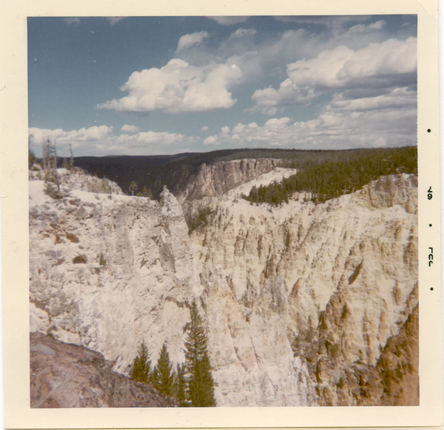Ein tiefer Canyon mit gelben und rostroten Felswänden, unten der Fluss, am Kopf ein hoher Wasserfall